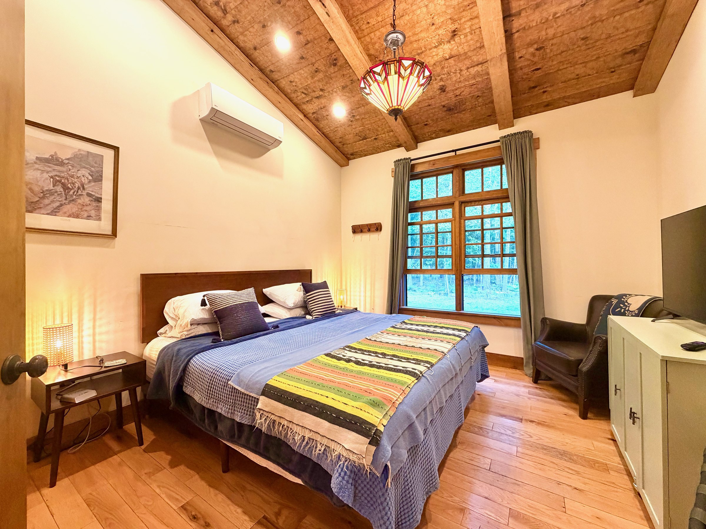 First Floor King bedroom with wood-beam ceiling at Wild Ausable Lodge