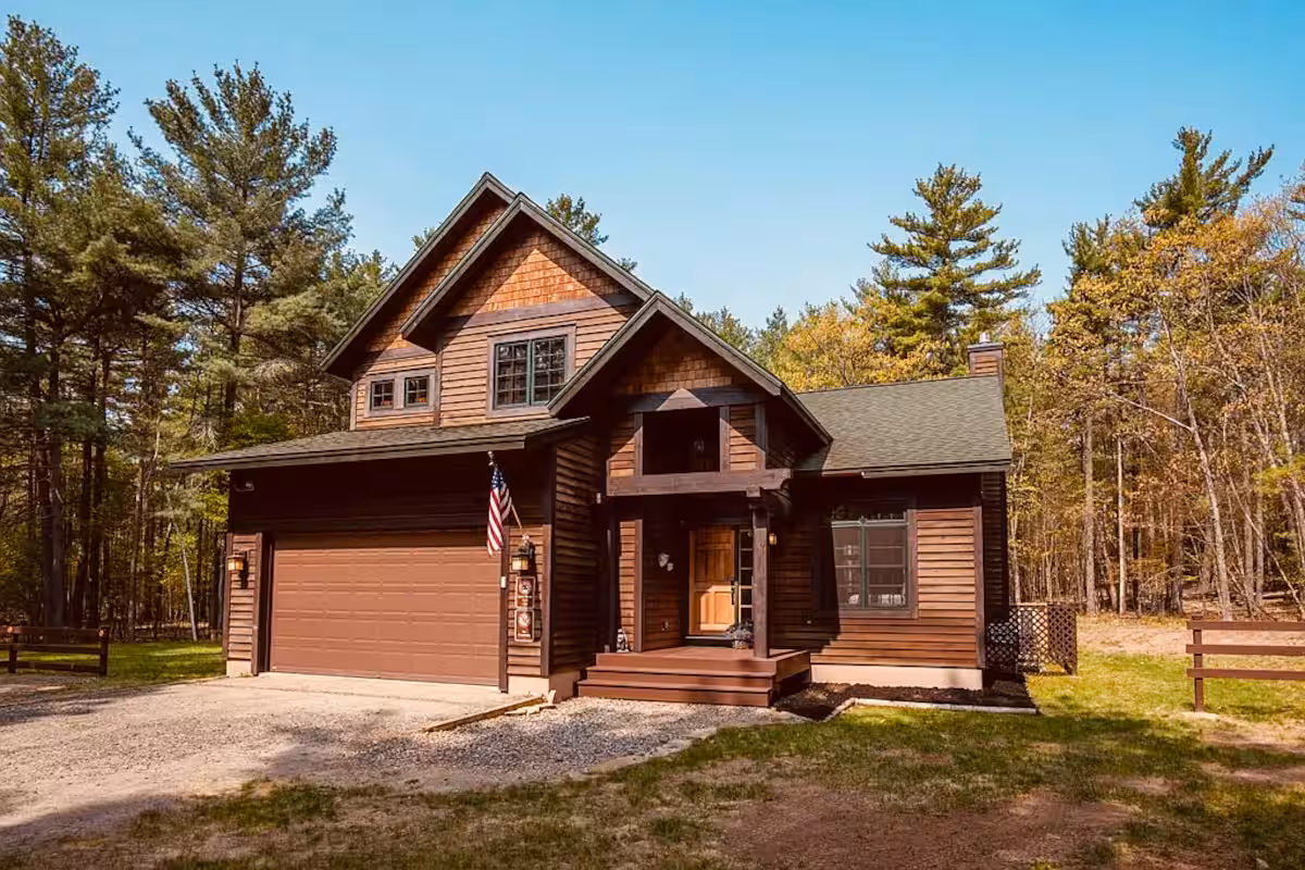 Wild Ausable Lodge exterior framed by tall Adirondack trees