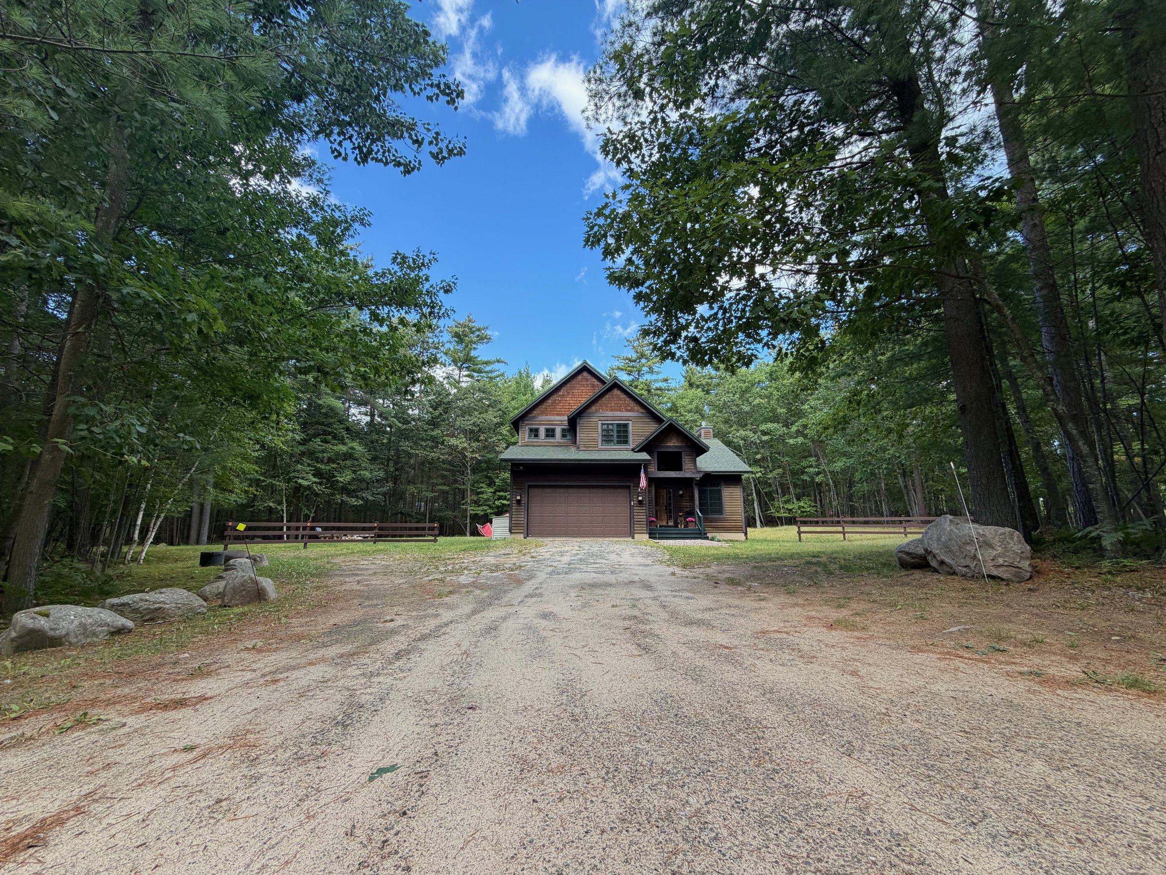 Gravel driveway leading to Wild Ausable Lodge through the trees